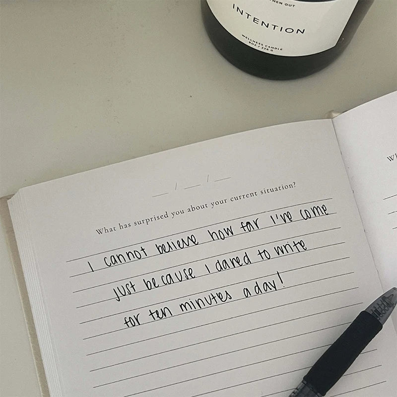 Open journal with handwritten text, pen, and journal prompt for self-reflection, mindfulness, mental health support, and gratitude.