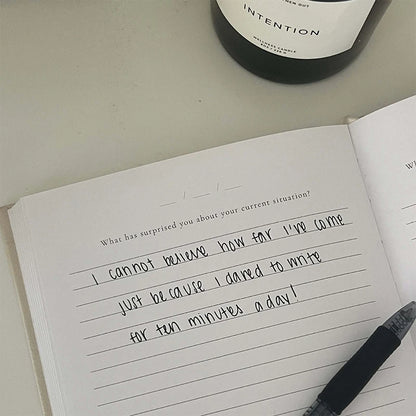 Open journal with handwritten text, pen, and journal prompt for self-reflection, mindfulness, mental health support, and gratitude.